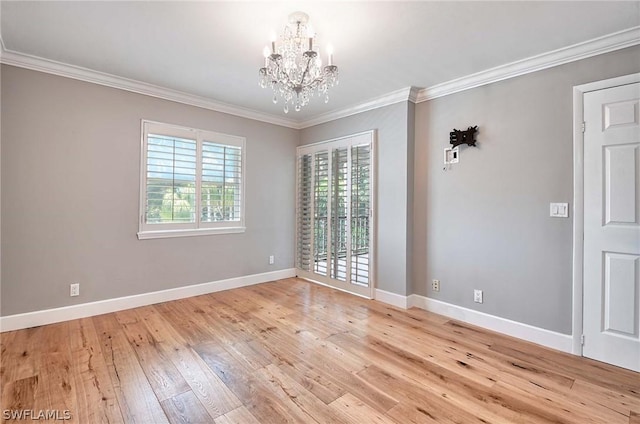 unfurnished room featuring ornamental molding, light hardwood / wood-style floors, and a chandelier