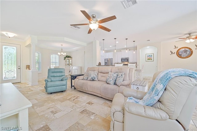 living room featuring ornamental molding and ceiling fan with notable chandelier