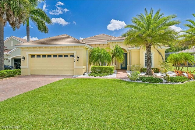 mediterranean / spanish house featuring a garage and a front yard