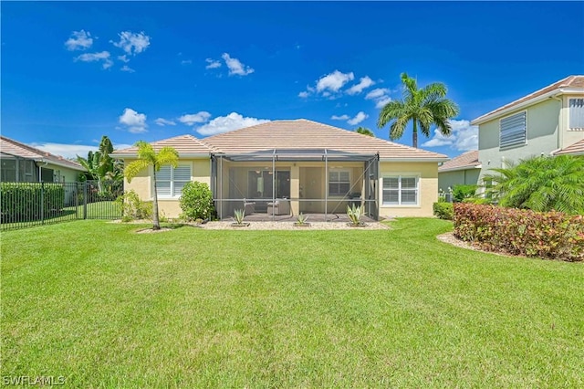 back of property featuring a lawn and glass enclosure