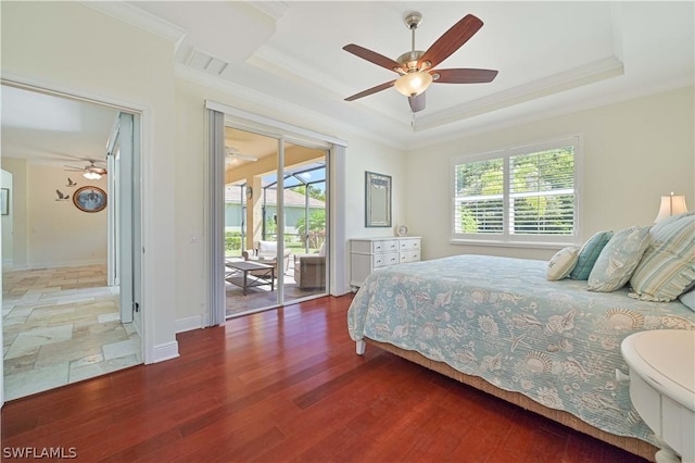 bedroom featuring multiple windows, access to outside, and a tray ceiling