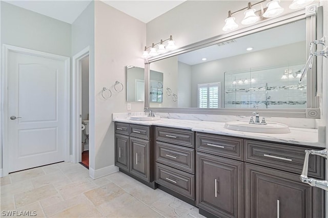 bathroom featuring vanity, toilet, and a shower with door