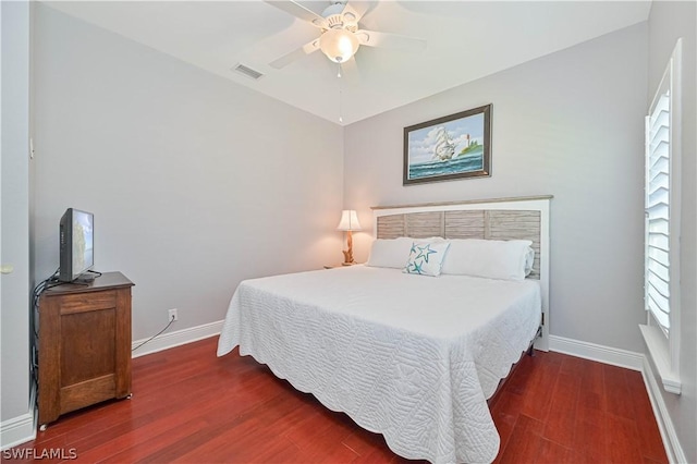 bedroom with ceiling fan, dark hardwood / wood-style floors, and multiple windows