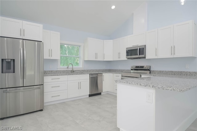 kitchen with appliances with stainless steel finishes, white cabinetry, and light stone counters