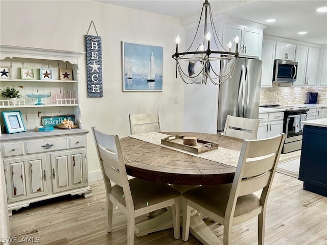 dining area with an inviting chandelier and light wood-type flooring