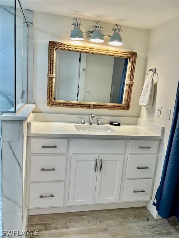 bathroom featuring vanity, wood-type flooring, and a shower