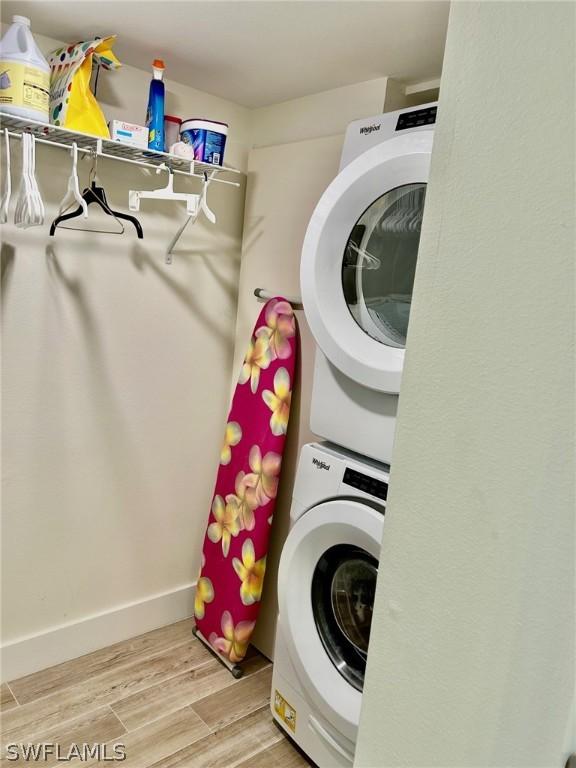 clothes washing area featuring stacked washer / dryer and hardwood / wood-style floors