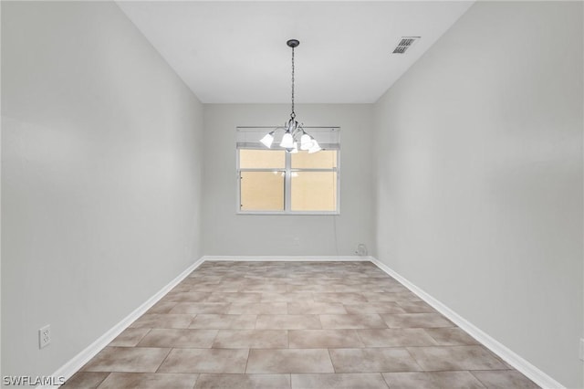 spare room featuring an inviting chandelier