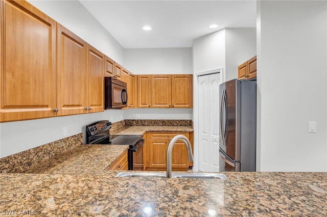 kitchen featuring stone counters, sink, and black appliances