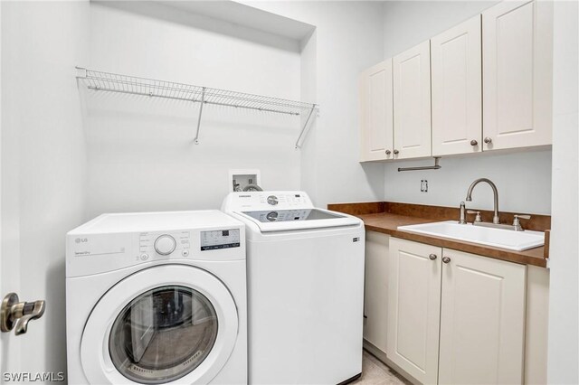 laundry area with cabinets, sink, light tile patterned floors, and washer and clothes dryer