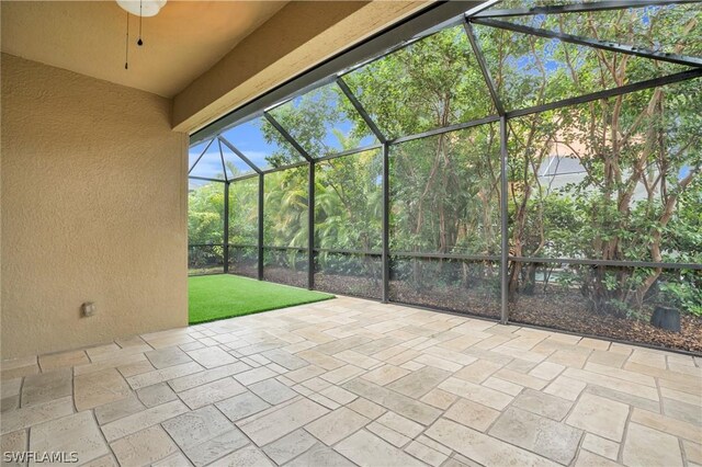 view of patio featuring ceiling fan and glass enclosure