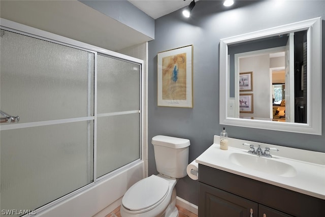 full bathroom with vanity, bath / shower combo with glass door, and toilet