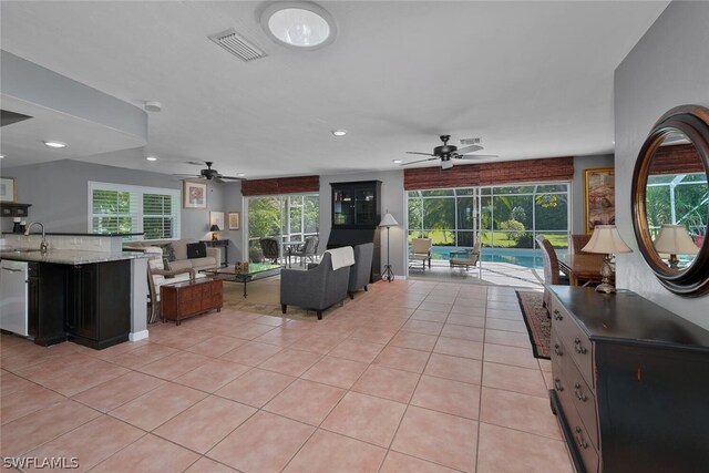 living room with sink, ceiling fan, and light tile patterned floors