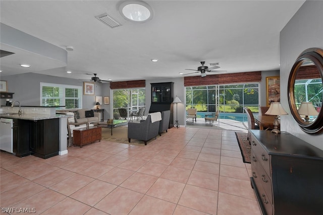 living room with light tile patterned flooring, ceiling fan, and sink