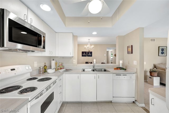 kitchen featuring pendant lighting, sink, white appliances, and white cabinets