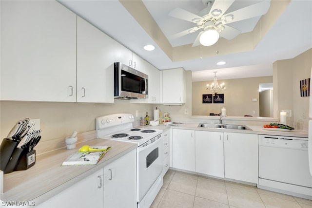 kitchen featuring sink, a raised ceiling, pendant lighting, white appliances, and white cabinets