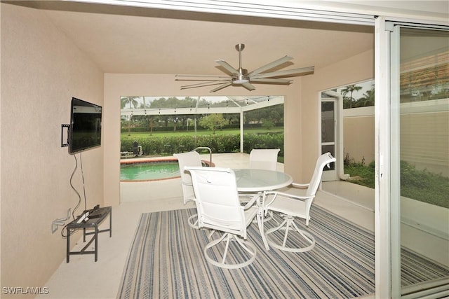 sunroom / solarium featuring a ceiling fan