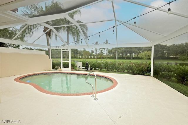 outdoor pool with glass enclosure and a patio area