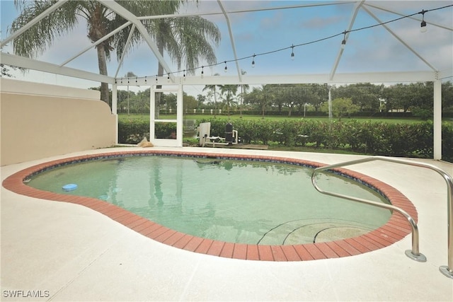 outdoor pool featuring a patio area and glass enclosure