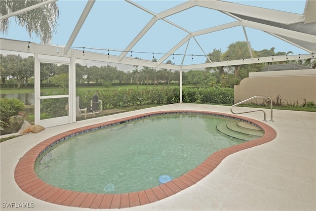 outdoor pool with glass enclosure and a patio area