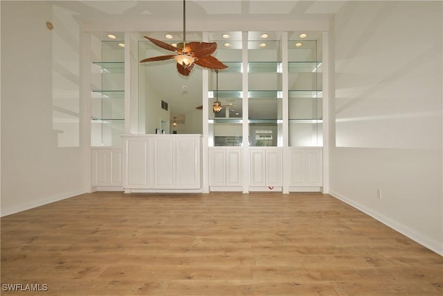 spare room featuring light wood-style floors, visible vents, baseboards, and a ceiling fan