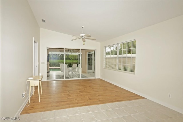 unfurnished room featuring a ceiling fan, vaulted ceiling, visible vents, and light wood-style floors