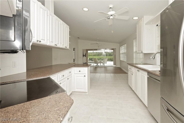 kitchen with stainless steel appliances, white cabinetry, a sink, and a peninsula