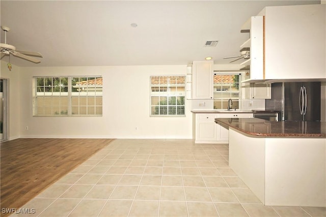 kitchen with ceiling fan, visible vents, white cabinetry, and freestanding refrigerator