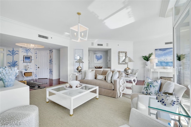 living room featuring crown molding, wood-type flooring, and a notable chandelier