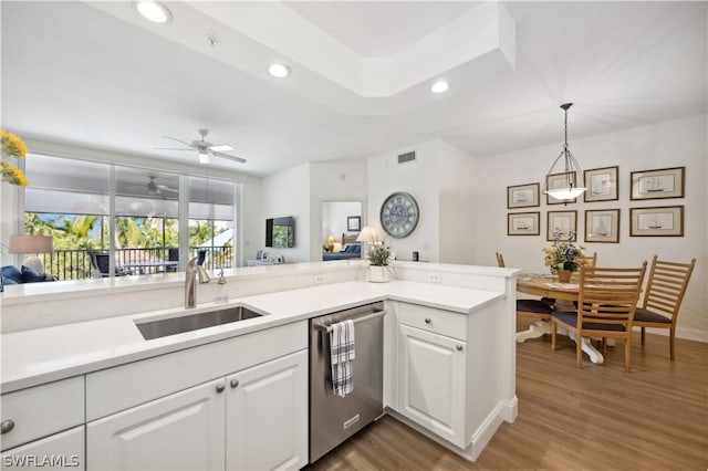 kitchen featuring sink, dark wood-type flooring, dishwasher, white cabinetry, and decorative light fixtures