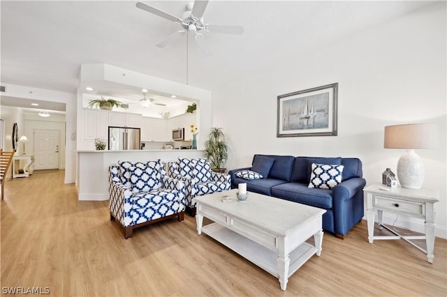 living room featuring ceiling fan and light hardwood / wood-style flooring