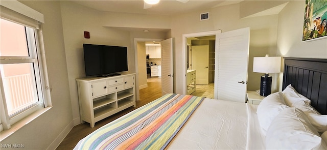 bedroom featuring light wood-type flooring and ensuite bathroom