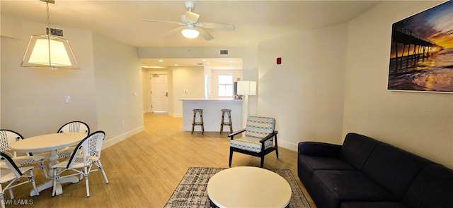 living room featuring light hardwood / wood-style flooring and ceiling fan