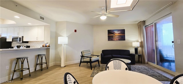 living room with ceiling fan and light wood-type flooring