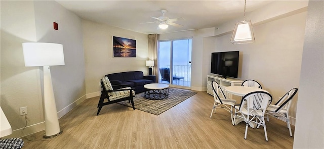 living room with ceiling fan and light hardwood / wood-style flooring