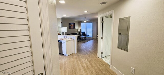 corridor featuring light wood-type flooring and electric panel