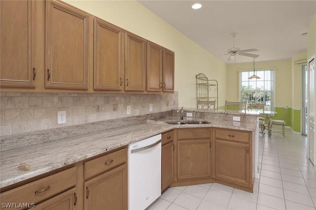 kitchen with white dishwasher, sink, light tile patterned floors, and kitchen peninsula