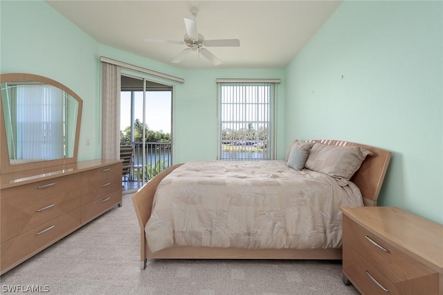 bedroom featuring a water view, vaulted ceiling, light carpet, ceiling fan, and access to exterior