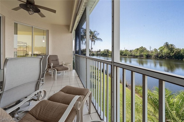 sunroom featuring a water view and ceiling fan