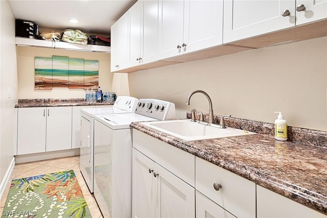 washroom with sink, light tile patterned floors, washer and clothes dryer, and cabinets