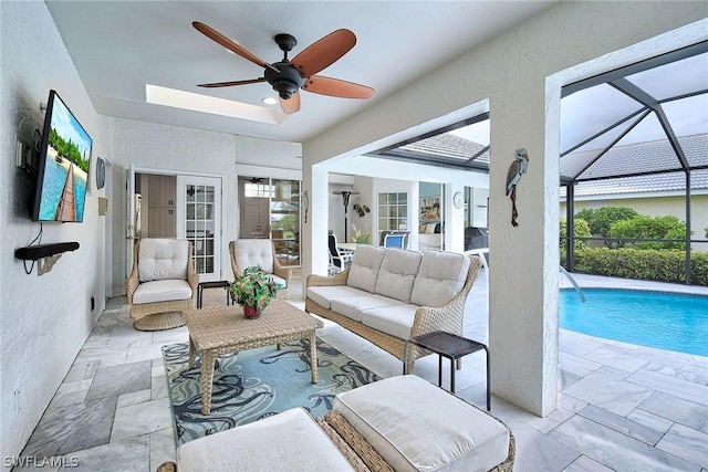 living room featuring a healthy amount of sunlight, a tray ceiling, and ceiling fan