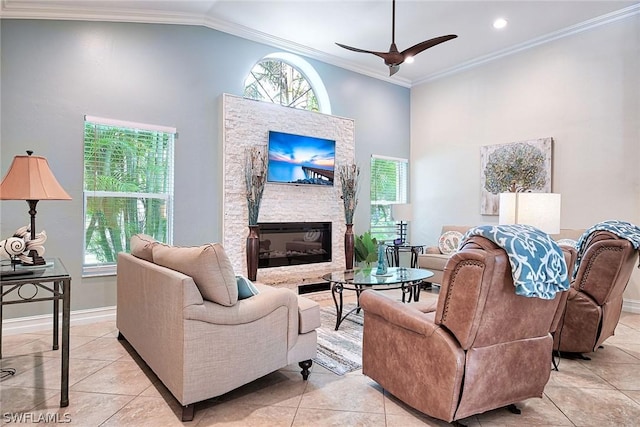 tiled living room featuring crown molding, a fireplace, high vaulted ceiling, and ceiling fan