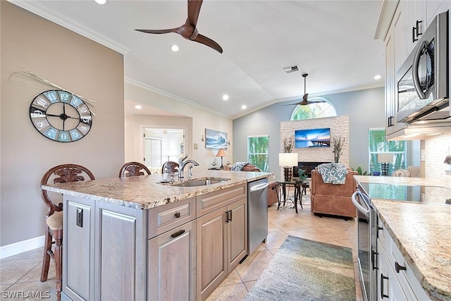 kitchen featuring stainless steel appliances, sink, a center island with sink, and ceiling fan