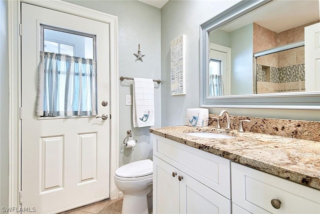 bathroom featuring vanity, toilet, a shower with door, and tile patterned flooring