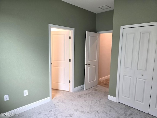 unfurnished bedroom with light carpet and a closet