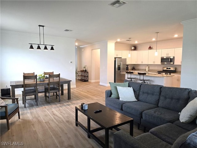 living room with crown molding and light hardwood / wood-style flooring