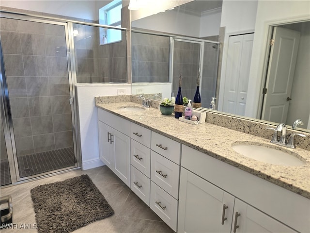 bathroom featuring tile patterned flooring, ornamental molding, dual vanity, and a shower with door