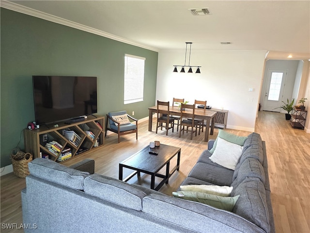 living room with light hardwood / wood-style flooring and ornamental molding