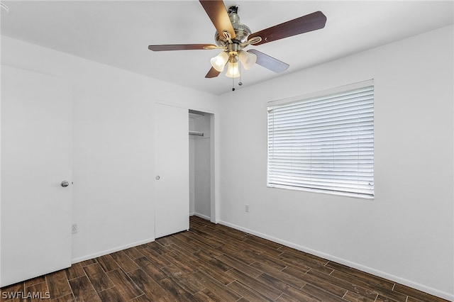 unfurnished bedroom with ceiling fan, a closet, and dark hardwood / wood-style floors