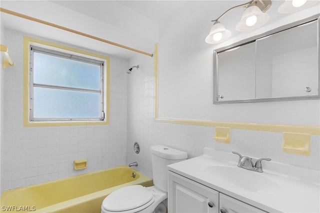 full bathroom featuring vanity, tiled shower / bath combo, toilet, and tile walls